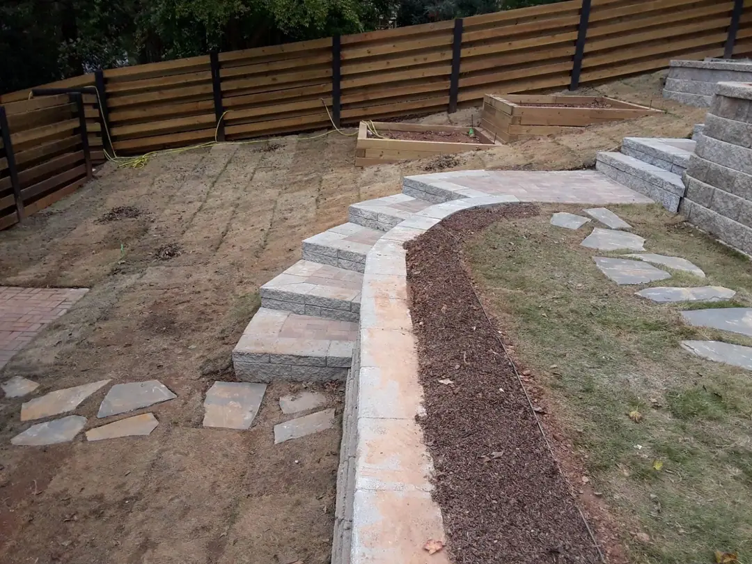 Stained horizontal wood fence above new stone steps and garden beds